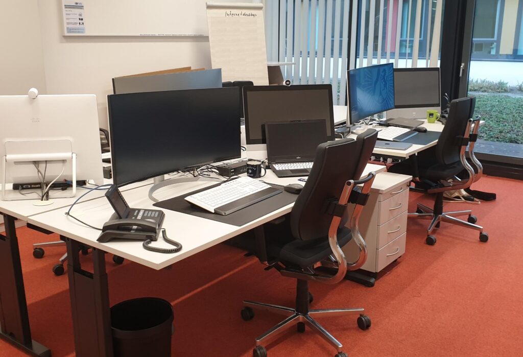 Anordnung von Bildschirmen und PCs in einem 4er Büro